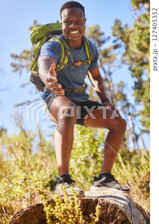 Black man, hiking and help hand, smile and happy outdoor in nature, forest or nature park in summer. Climbing up hill, trekking together in nature and healthy workout adventure, pov and fitness hiker 127405352