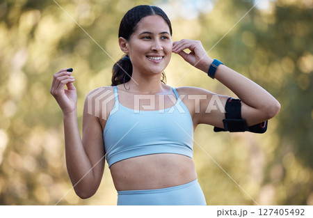 Runner fitness, music and woman marathon training in nature park for healthcare wellness, sports motivation and cardio exercise. Young girl, streaming radio podcast and relax health workout outdoor Runner fitness, music and woman marathon training in nature park for healthcare wellness, sports motivation and cardio exercise. Young girl, streaming radio podcast and relax health workout outdoor 127405492