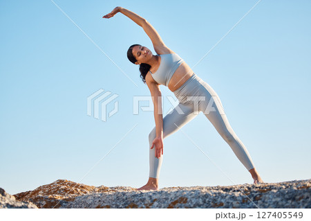 Fitness, health and yoga with a woman athlete stretching on a rock at the beach for mental health or wellness. Exercise, workout and training with a female yogi outdoor in nature for mindfulness Fitness, health and yoga with a woman athlete stretching on a rock at the beach for mental health or wellness. Exercise, workout and training with a female yogi outdoor in nature for mindfulness 127405549