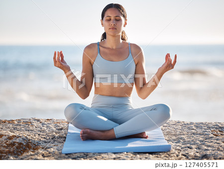 Calm, beach and woman doing meditation exercise for zen, health and wellness of the mind and body. Spiritual, fitness and healthy girl in lotus pose doing yoga or pilates workout by the ocean or sea. Calm, beach and woman doing meditation exercise for zen, health and wellness of the mind and body. Spiritual, fitness and healthy girl in lotus pose doing yoga or pilates workout by the ocean or sea. 127405571