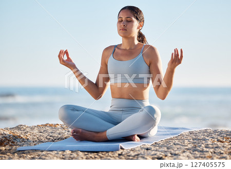 Woman, beach and yoga meditation for mind, body and spiritual wellness in summer sunshine. Girl, fitness or training for zen, mindfulness or peace by ocean, sea or sky for self care, relax or breathe 127405575