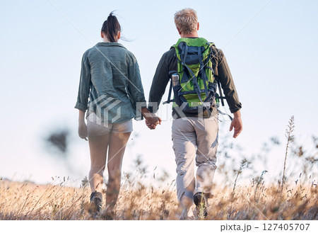 Couple, holding hands and travel or backpack adventure in bonding relationship together in the countryside. Hands of man and woman backpacking, trekking or walking in care or support for traveling 127405707