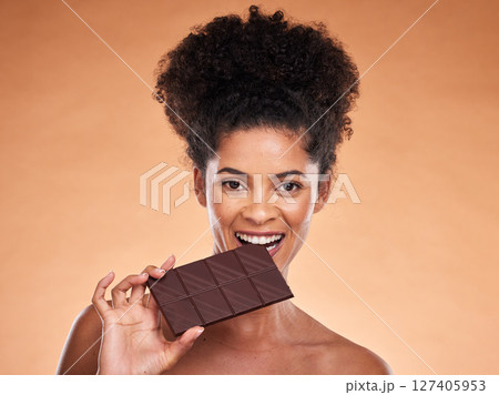 Chocolate, happy woman and beauty portrait, studio background and eating sweets, cacao dessert and enjoy sugar. Black woman bite chocolate bar, cocoa and candy, diet calories and snack temptation Chocolate, happy woman and beauty portrait, studio background and eating sweets, cacao dessert and enjoy sugar. Black woman bite chocolate bar, cocoa and candy, diet calories and snack temptation 127405953