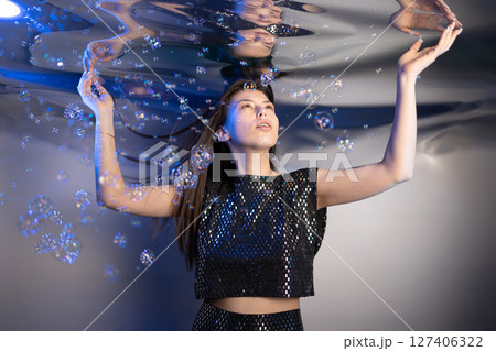 Girl in Shimmering Outfit Creates a Magical Mermaid Moment Beneath Bubbles 127406322
