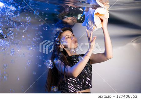 Girl Exploring Underwater World as a Fabulous Mermaid With a Large Shell 127406352