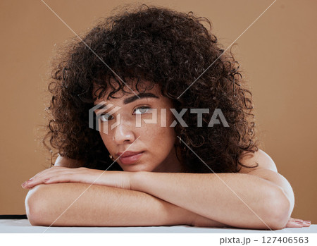Face, beauty and skincare with a model black woman in studio on a brown background for natural haircare. Portrait, cosmetics and wellness with an attractive young female posing to promote hair care 127406563