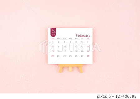 February 2026 calendar page with wooden easel on pink color background. February 2026 calendar page with wooden easel on pink color background. 127406598