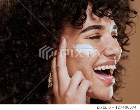 Cream, woman and skincare for wellness, natural beauty and confident on brown studio background. Cosmetics, female and girl with lotion, smooth face and organic facial with smile, happy and freckles. 127406674