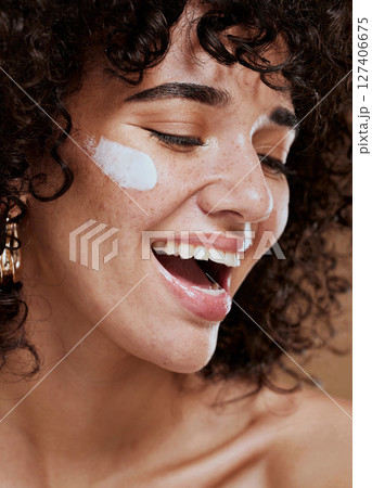 Beauty, skincare and woman with face cream in a studio with a healthy, natural and skin treatment. Wellness, health and happy young model doing a face routine with facial creme, sunscreen or spf. 127406675