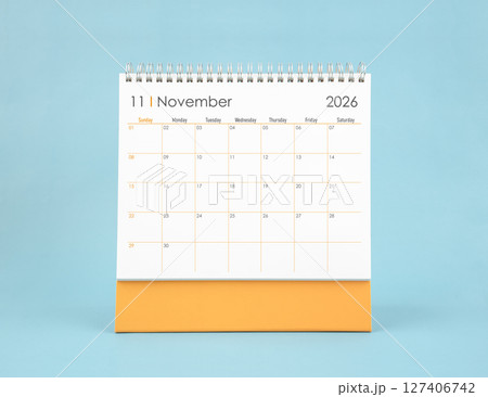 November 2026 white desk calendar on blue color background. Planning and goals concepts. 127406742