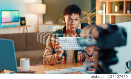 Man, keyboard and recording with video camera for online streaming, gamer tips or tutorial at home. Male person, influencer or videographer with technology for vlog, gaming advice or review at house Man, keyboard and recording with video camera for online streaming, gamer tips or tutorial at home. Male person, influencer or videographer with technology for vlog, gaming advice or review at house 127407479