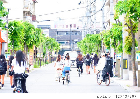 花園ラグビー場前のスクラムロードを自転車で行く女子たち 127407507