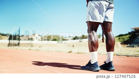Legs, athlete and man for fitness at stadium for training, exercise and marathon practice on track field. Male runner, starting line and endurance for sports event, cardio performance and preparation 127407528