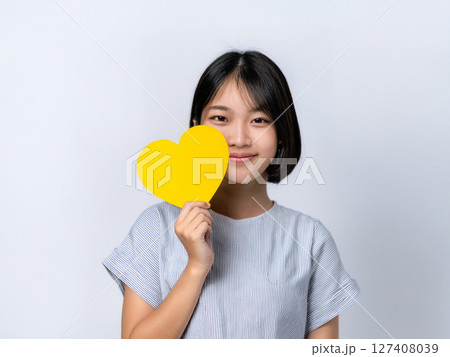 黄色いハートのカードを持つ学生 127408039