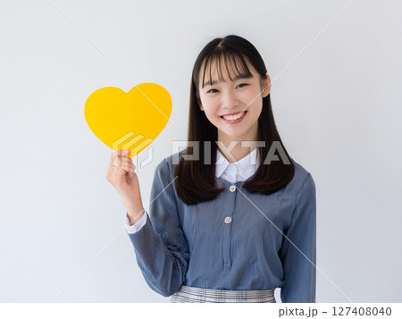 黄色いハートのカードを持つ学生 127408040