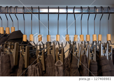 Stylish clothing arranged on hangers in a boutique. High quality photo 127408981