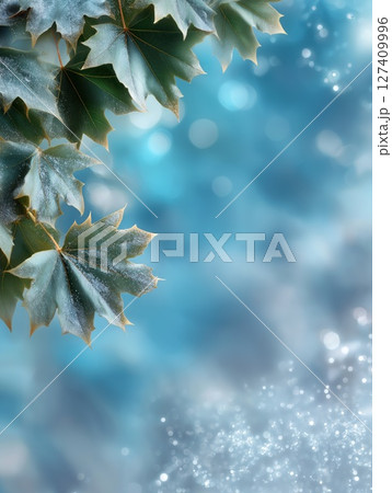 Frosted green maple leaves on dreamy blue backdrop with soft bokeh, sparkling effects, copy space 127409996