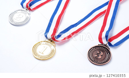 Gold silver and bronze demonstration trophy medals with ribbon for school university or national or olympic sport even organization competition. Isolated on white background. Award and victory concept 127410355