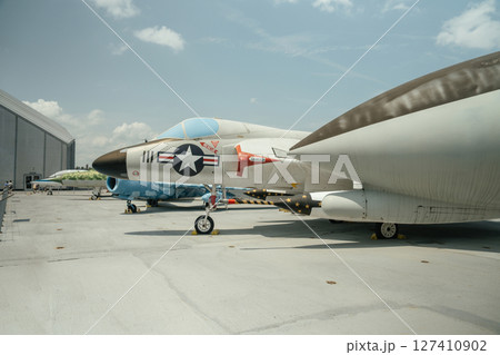 A vintage U.S. military jet is displayed outdoors on a rooftop exhibit. The aircraft features classic Air Force markings and a sleek aerodynamic design. A vintage U.S. military jet is displayed outdoors on a rooftop exhibit. The aircraft features classic Air Force markings and a sleek aerodynamic design. 127410902