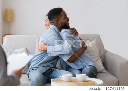 Happy Reconciling. Loving Afro Spouses Hugging At Psychologist's Office After Effective Marital Therapy. Selective Focus, Free Space Happy Reconciling. Loving Afro Spouses Hugging At Psychologist's Office After Effective Marital Therapy. Selective Focus, Free Space 127411193
