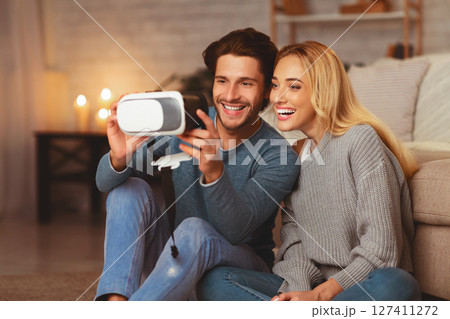 Excited Couple Trying Virtual Reality Glasses Having Fun At Home In The Evening. Selective Focus 127411272