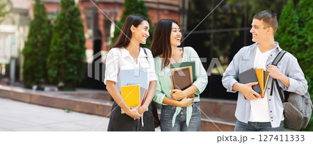 Popular Guy In Campus. Handsome University Student Chatting With Two Female Classmates Outdoors 127411333