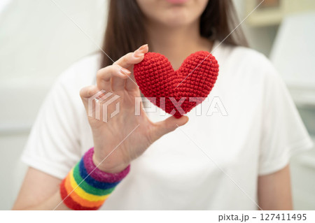 Asian LGBT woman holding heart rainbow flag. 127411495