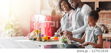 Lovely african vegan family making healthy dinner together, daughter learning cooking, parents making salad, copy space Lovely african vegan family making healthy dinner together, daughter learning cooking, parents making salad, copy space 127411638
