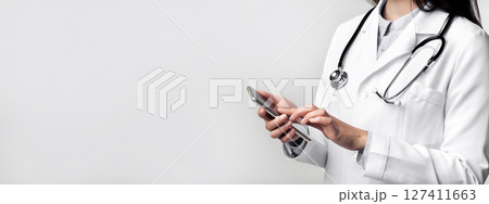 Medical App. Unrecognizable Doctor Using Smartphone Standing On White Studio Background. Cropped 127411663