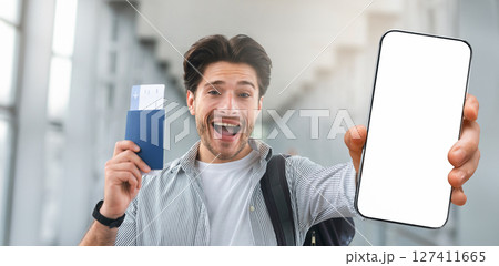 Time To Travel. Joyful handsome guy taking selfie with passport and poarding passes in airport 127411665