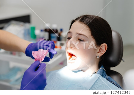 Dentist preparing dental impression tray for young patient 127412343