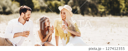 Young family having picnic outdoors, resting in nature and drinking orange juice Young family having picnic outdoors, resting in nature and drinking orange juice 127412355