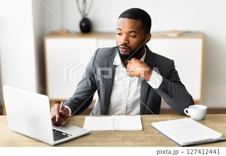 Portrait of confident black businessman in formal suit working in modern office interior, selective focus on man 127412441