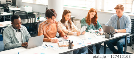Collaboration Concept. Group of diverse people sitting at the table, working, studying for test, making project or homework together, multiracial friends using laptops and writing on notepads Collaboration Concept. Group of diverse people sitting at the table, working, studying for test, making project or homework together, multiracial friends using laptops and writing on notepads 127413168