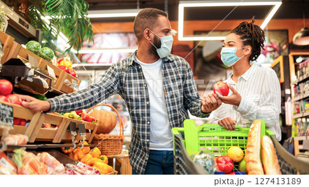 Grocery Shopping. African Family Couple In Masks Buying Vegetables Together Standing With Shop Cart In Supermarket Groceries Store Indoor. Buyers Choosing Healthy Food Concept 127413189