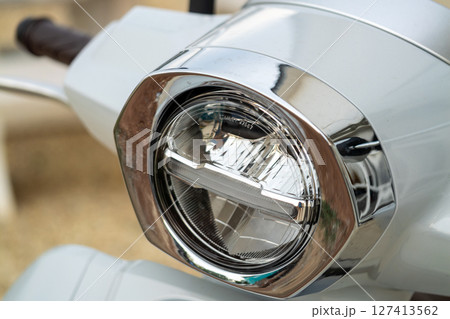 Sleek scooter headlight focus urban setting transport close-up modern aesthetic 127413562