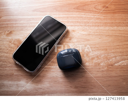 Mobile device and wireless earbuds home setting product minimalist style close-up view technology appeal Mobile device and wireless earbuds home setting product minimalist style close-up view technology appeal 127413958