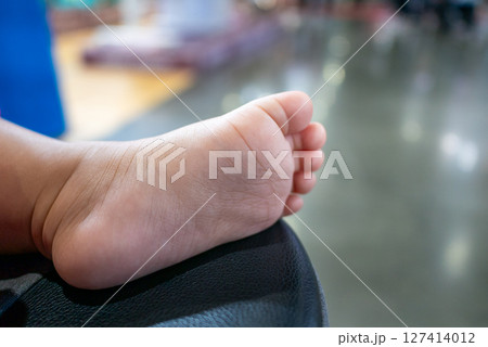 Toddler's playful foot touching soft surface indoor play area close-up vibrant environment Toddler's playful foot touching soft surface indoor play area close-up vibrant environment 127414012