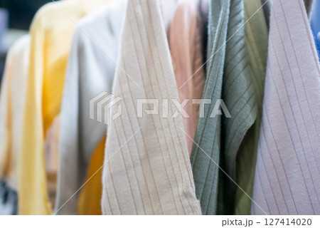 Fashion display colorful shirts hanging in a boutique lifestyle store indoor close-up retail vibe 127414020