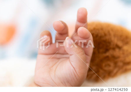 One year old asian girl's tiny hand reaching out home candid cozy close-up innocence One year old asian girl's tiny hand reaching out home candid cozy close-up innocence 127414250