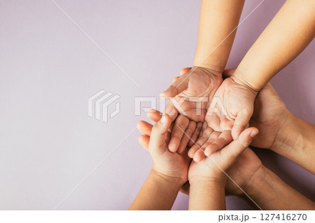 Parents and kid holding empty hands top view isolated on color background. Signifying Family Day unity support and the bond between generations. Parents and kid holding empty hands top view isolated on color background. Signifying Family Day unity support and the bond between generations. 127416270