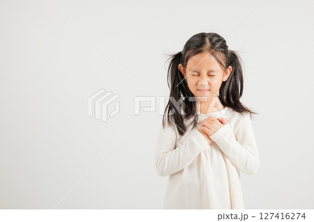 Young kid girl pressing on chest pain isolated on white background, painful expression heartache, kindergarten children having heart attack heart disease, Painful cramps problem Young kid girl pressing on chest pain isolated on white background, painful expression heartache, kindergarten children having heart attack heart disease, Painful cramps problem 127416274