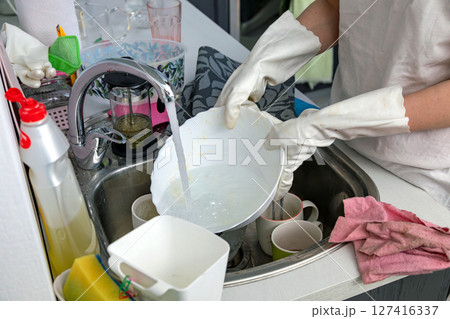 Woman washing dishes in the kitchen 127416337