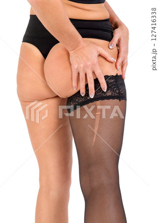 Woman in black stockings with big hole, isolated on white background. 127416338