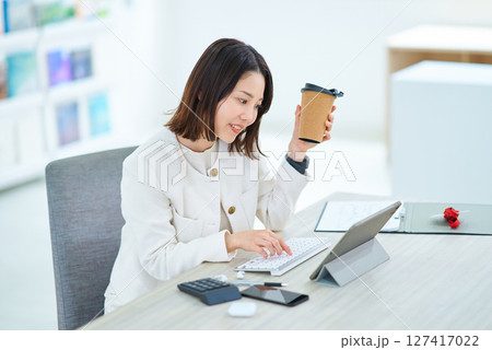仕事中にコーヒーを飲んで休憩する女性 127417022