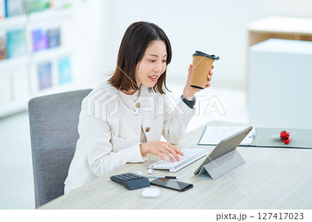 仕事中にコーヒーを飲んで休憩する女性 127417023