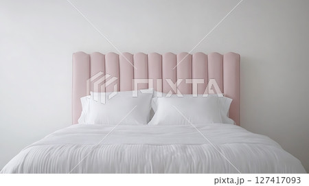 A bed with a pink headboard and white pillows 127417093