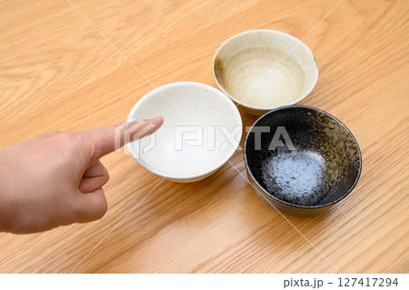 ご飯をよそう茶碗を選ぶ男性の手　食器選び　選び方 127417294