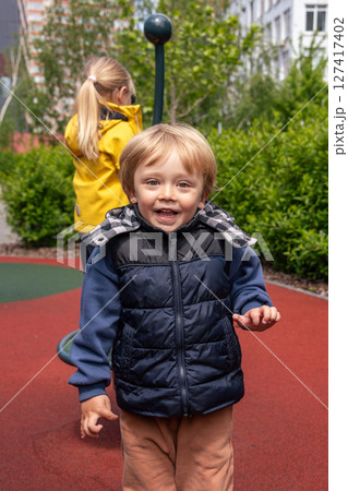 Two children enjoying their time at a vibrant playground on a sunny day. The image captures happiness and outdoor fun while highlighting the youthful energy of children engaging in play. Two children enjoying their time at a vibrant playground on a sunny day. The image captures happiness and outdoor fun while highlighting the youthful energy of children engaging in play. 127417402