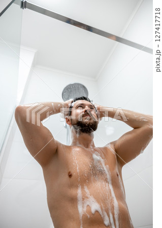 Man cleaning hair in white bathroom 127417718